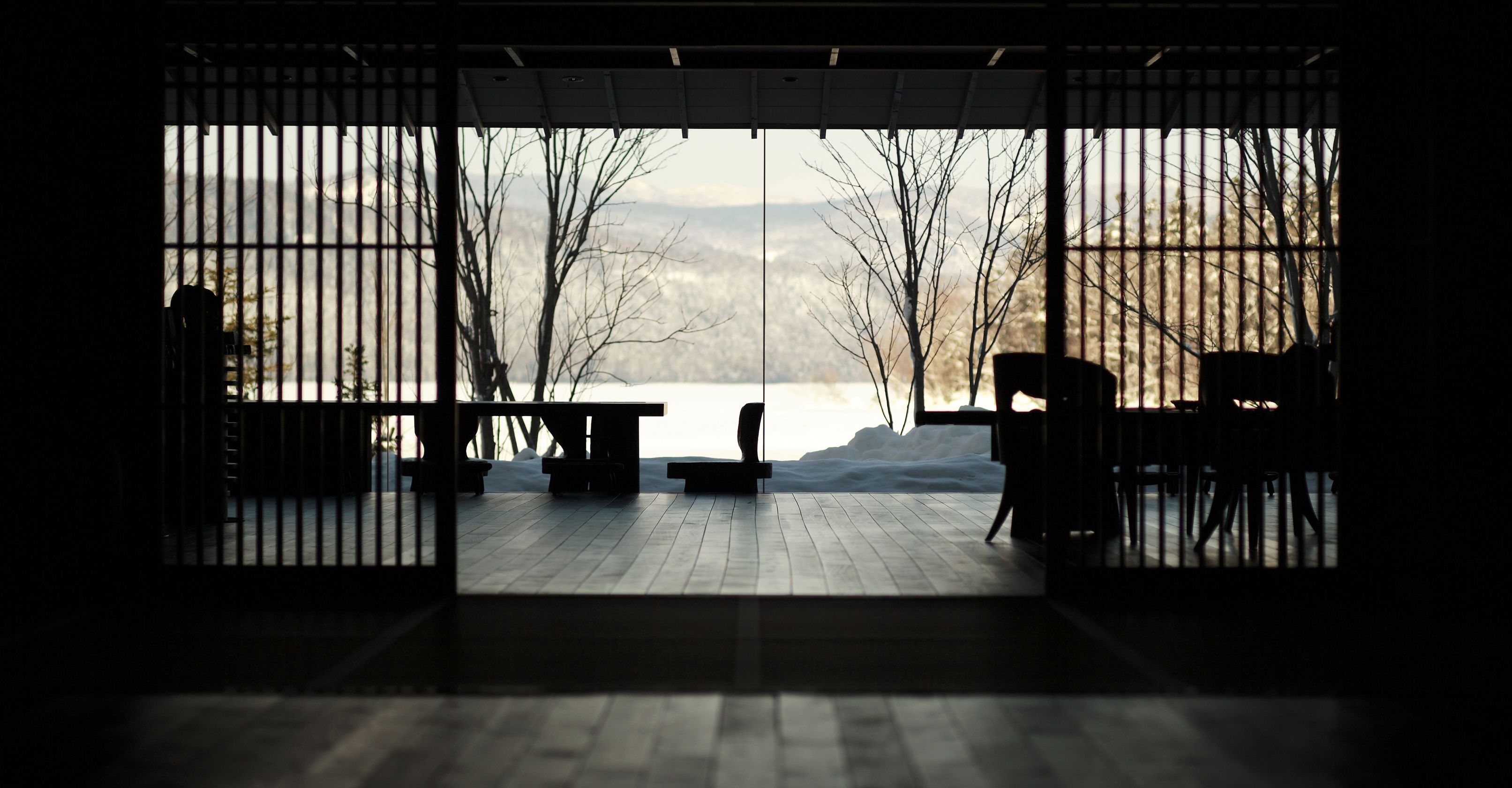 A room with a view of a snowy landscape through a large window.