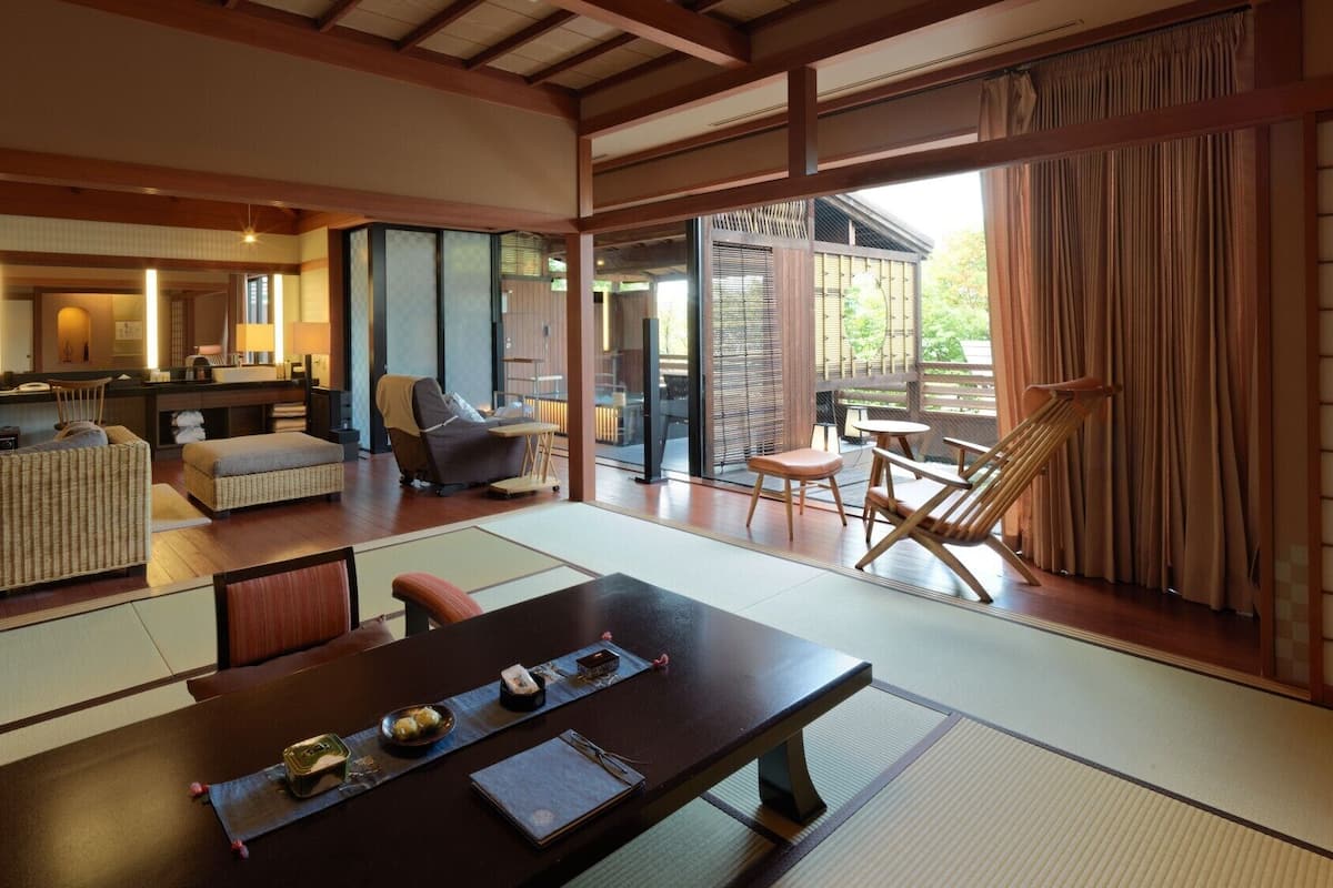 A traditional Japanese-style room with tatami flooring, a low table with a tray, and a view of the outside.