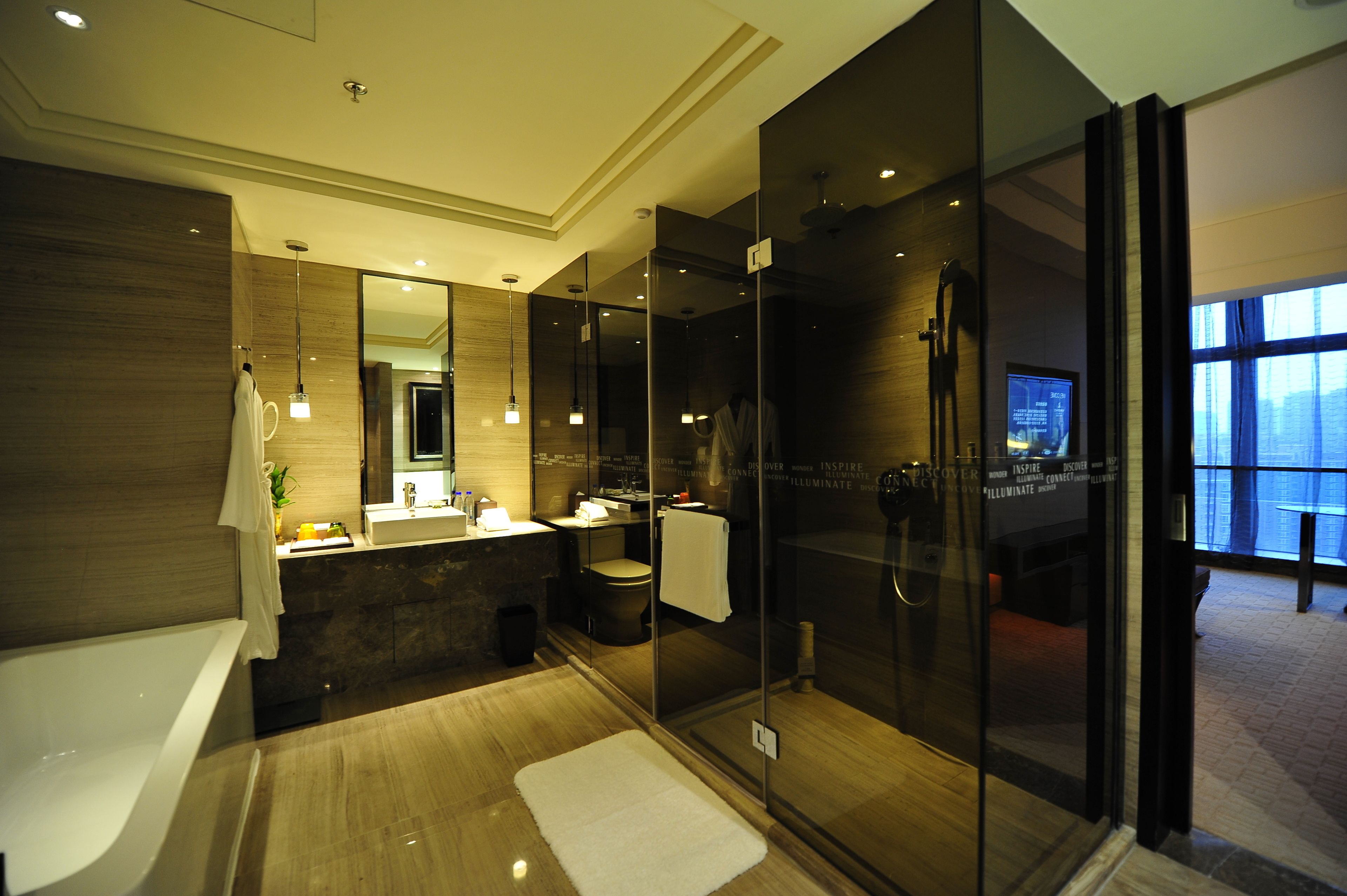 A modern bathroom with a glass-enclosed shower, a bathtub, and a vanity with a mirror.