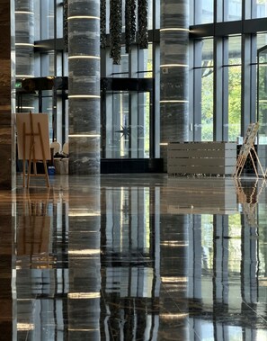 A spacious lobby with a polished floor, large windows, and modern architectural columns. - Renaissance Guiyang Hotel (Guiyang)