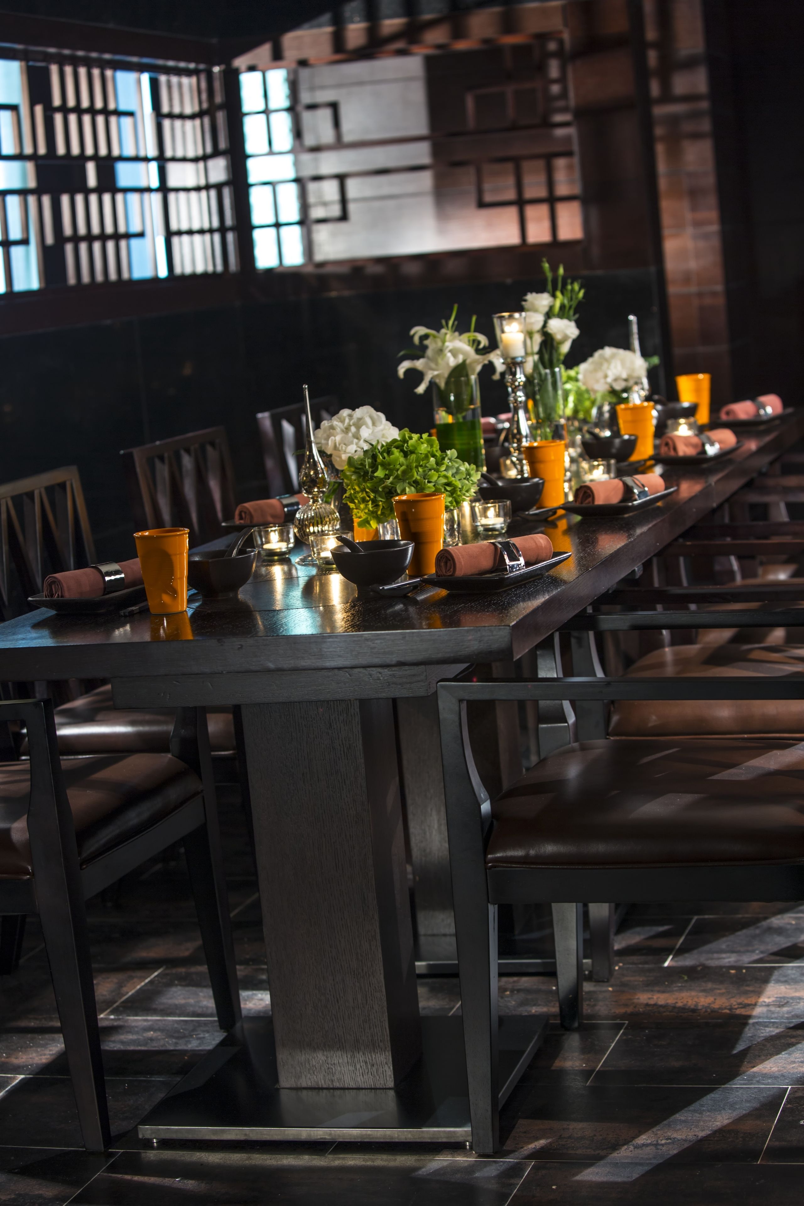 A long dining table set with chairs, candles, and decorative items.