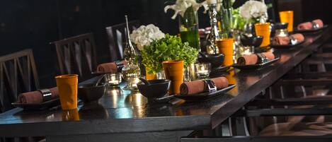 A long dining table set with chairs, candles, and decorative items.