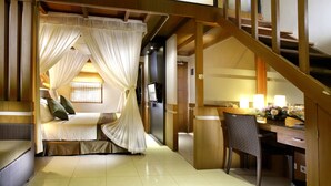 A room with a bed, a desk, and a chair. There is a staircase in the background. - The Banyumas Villa (Denpasar)