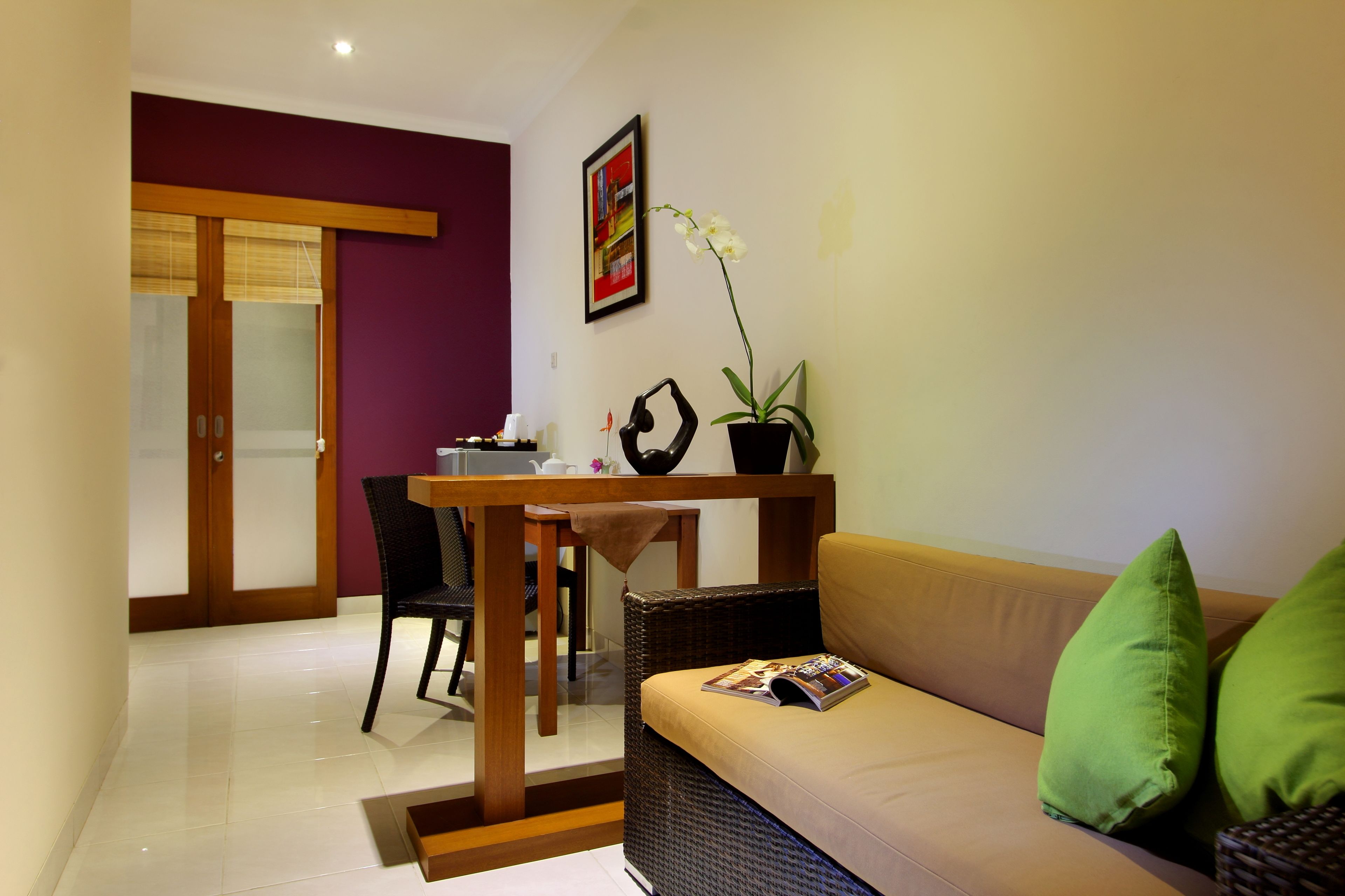 Una sala moderna con un sofá, una mesa de comedor y una orquídea en maceta.