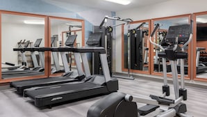 A gym with treadmills, elliptical machines, and weight equipment.