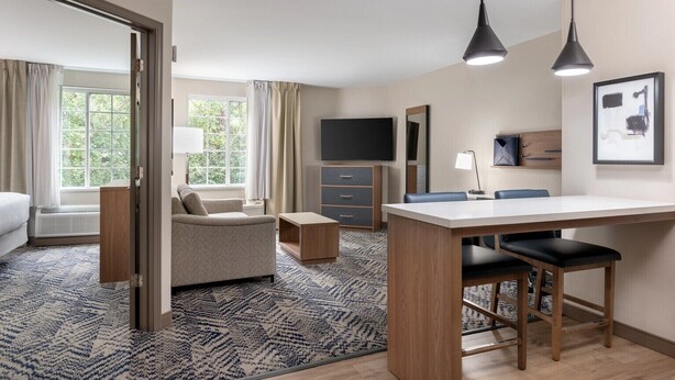 Et hotelværelse med en seng, en sofa, et skrivebord og et fjernsyn.