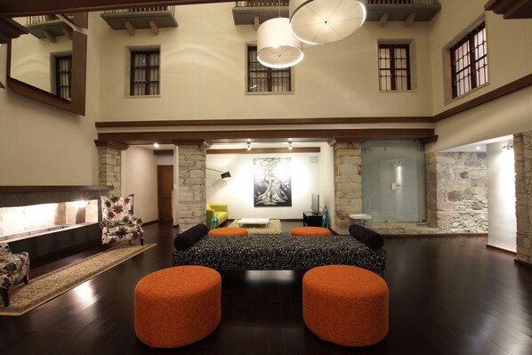 A spacious living area with a fireplace, a large painting, and a stone wall.