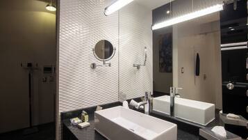Un bagno moderno con uno specchio grande, due lavabi e una zona doccia.