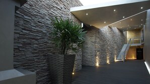 Un intérieur moderne avec des murs en pierre, un plancher en bois et un escalier menant à un niveau supérieur.
