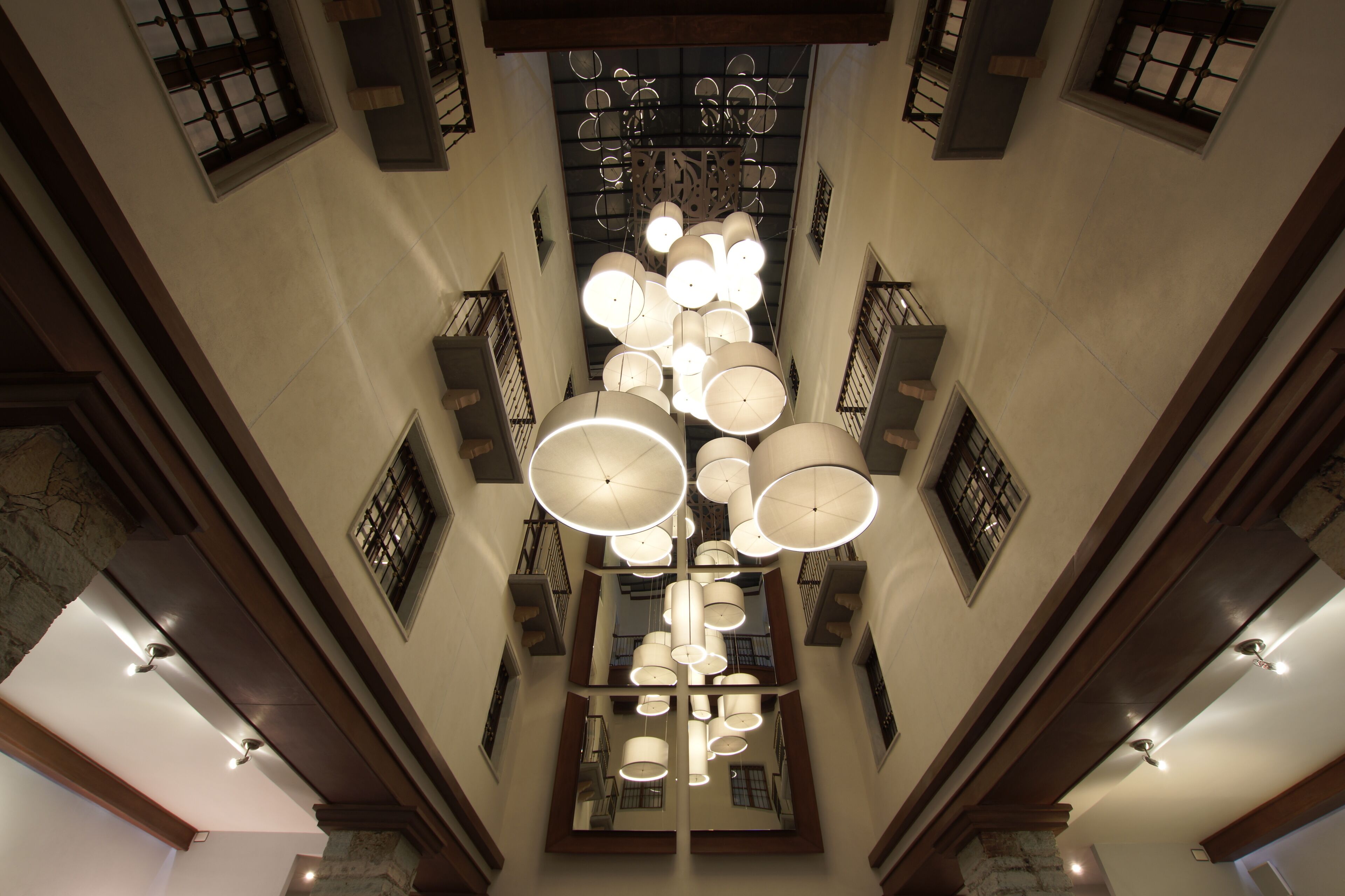 Un atrio amplio con techos altos, un candelabro central y varios balcones.
