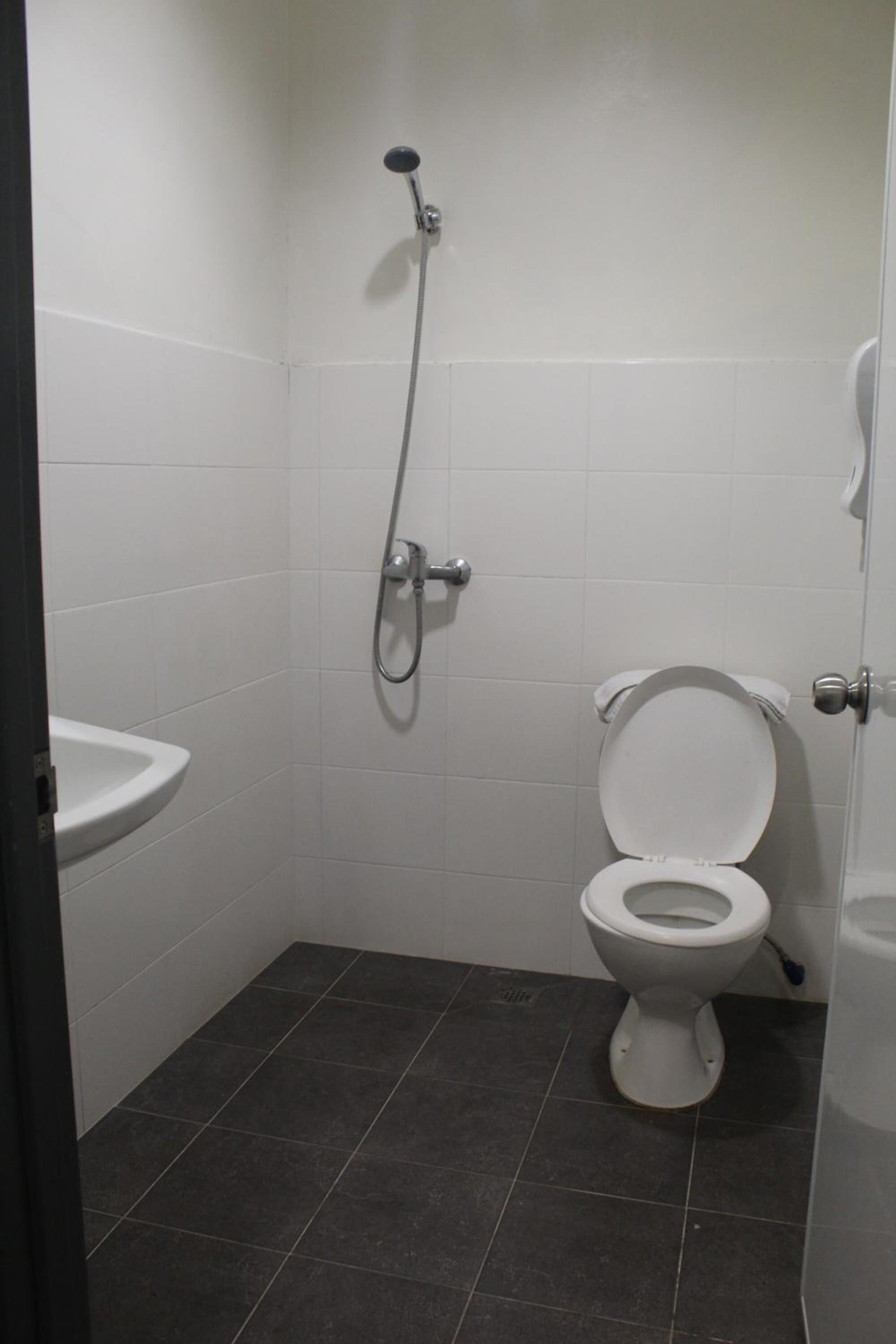 Un baño pequeño y limpio con inodoro, lavamanos y ducha.