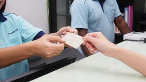 Una persona recibe una tarjeta de otra persona en un mostrador.