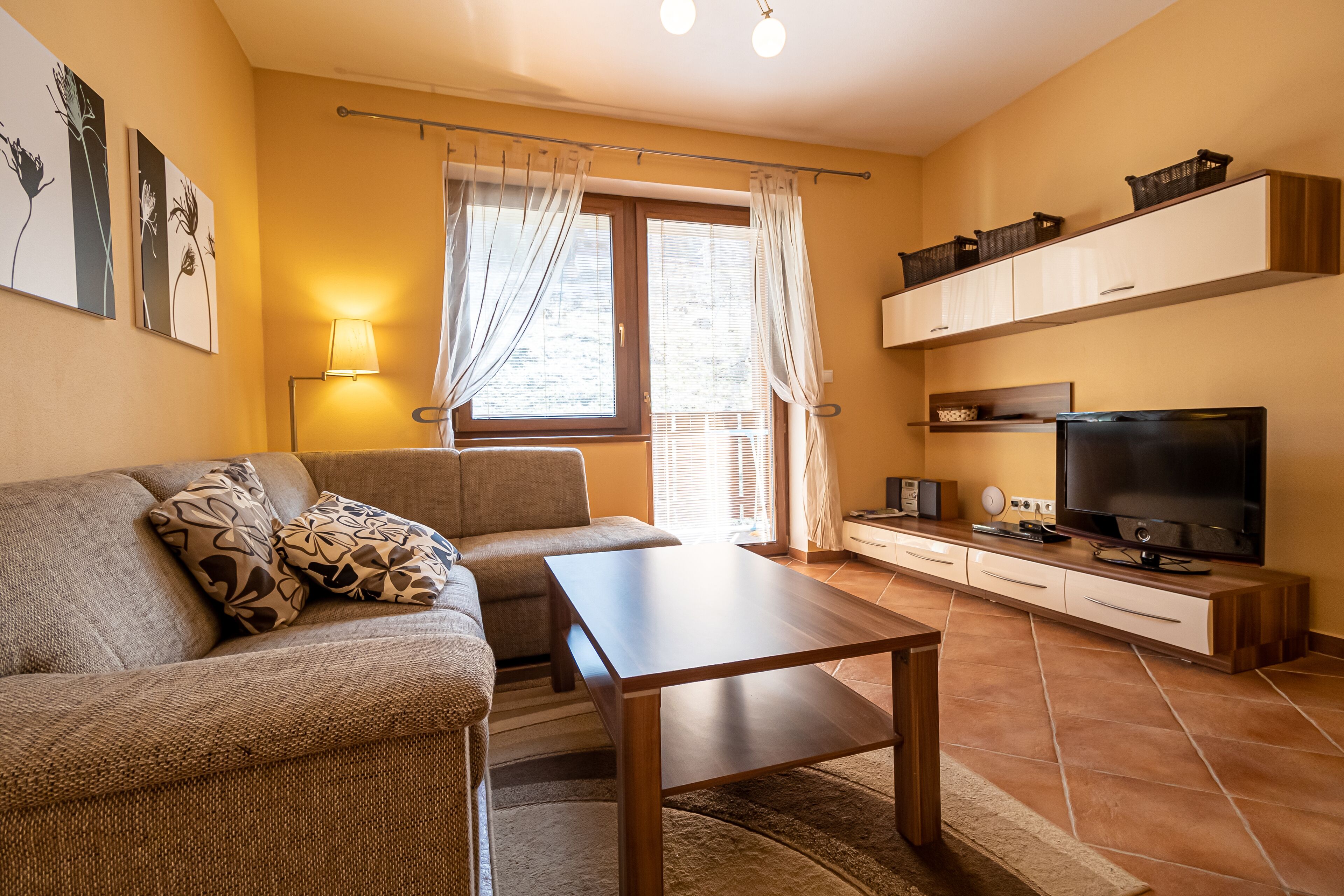 A living room with a sofa, a coffee table, a TV, and a cabinet.