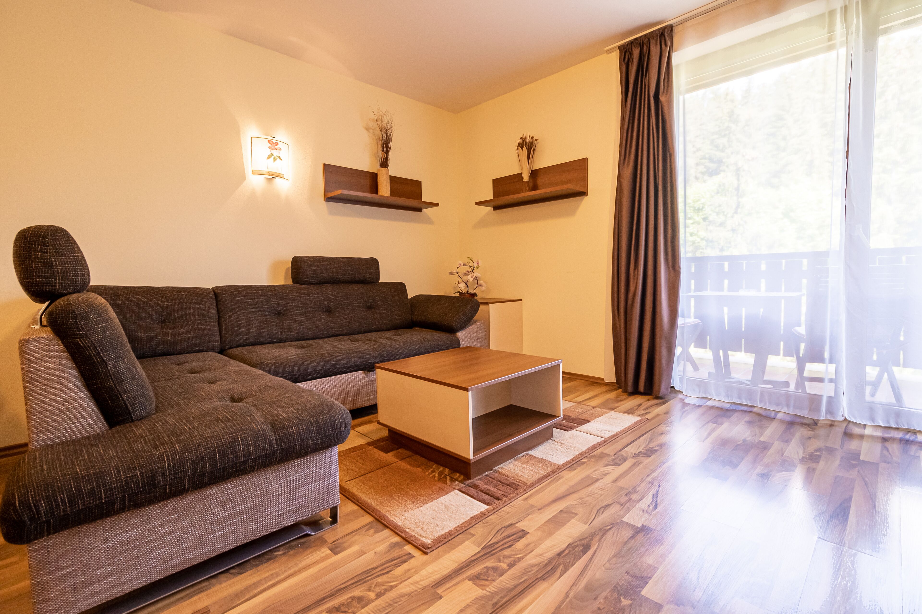 Una sala moderna con un sofá modular, una mesa de centro y dos estantes flotantes con adornos.