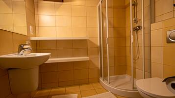 Un baño con lavamanos, inodoro y ducha.