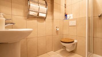 Ein kleines Badezimmer mit Toilette, Waschbecken und Dusche.