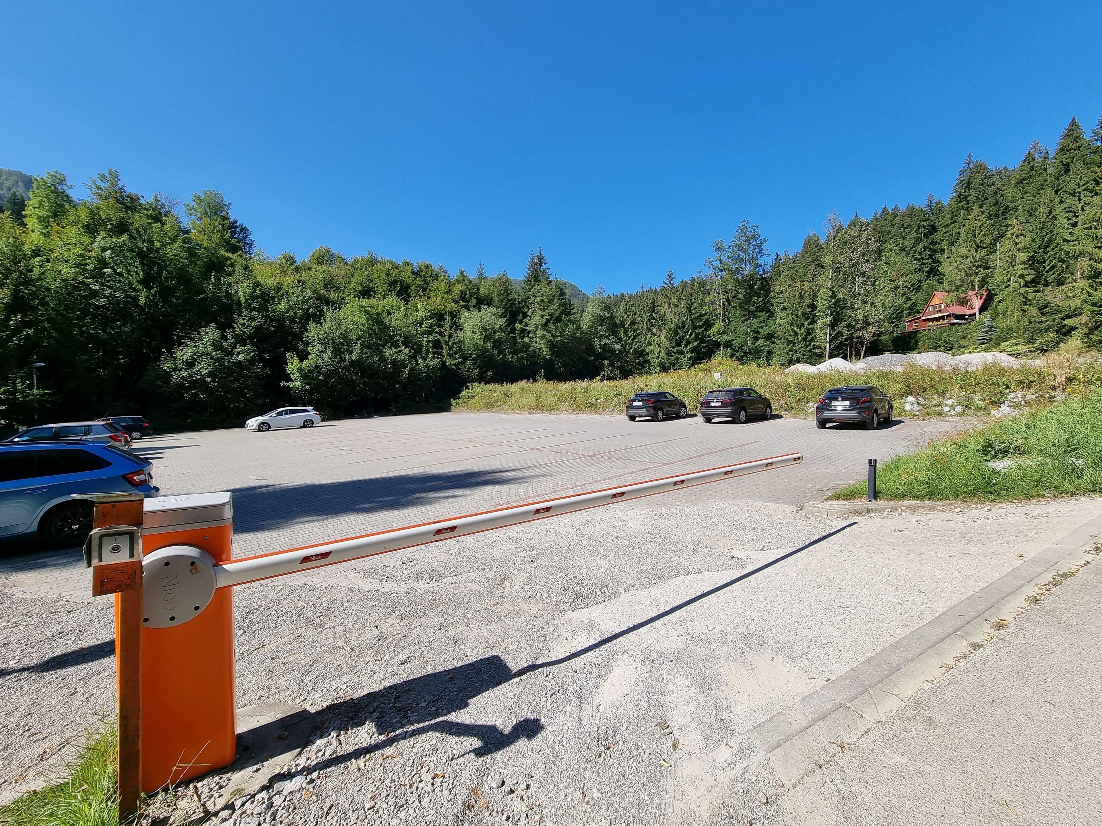 Un espace de stationnement avec des voitures et une barrière.