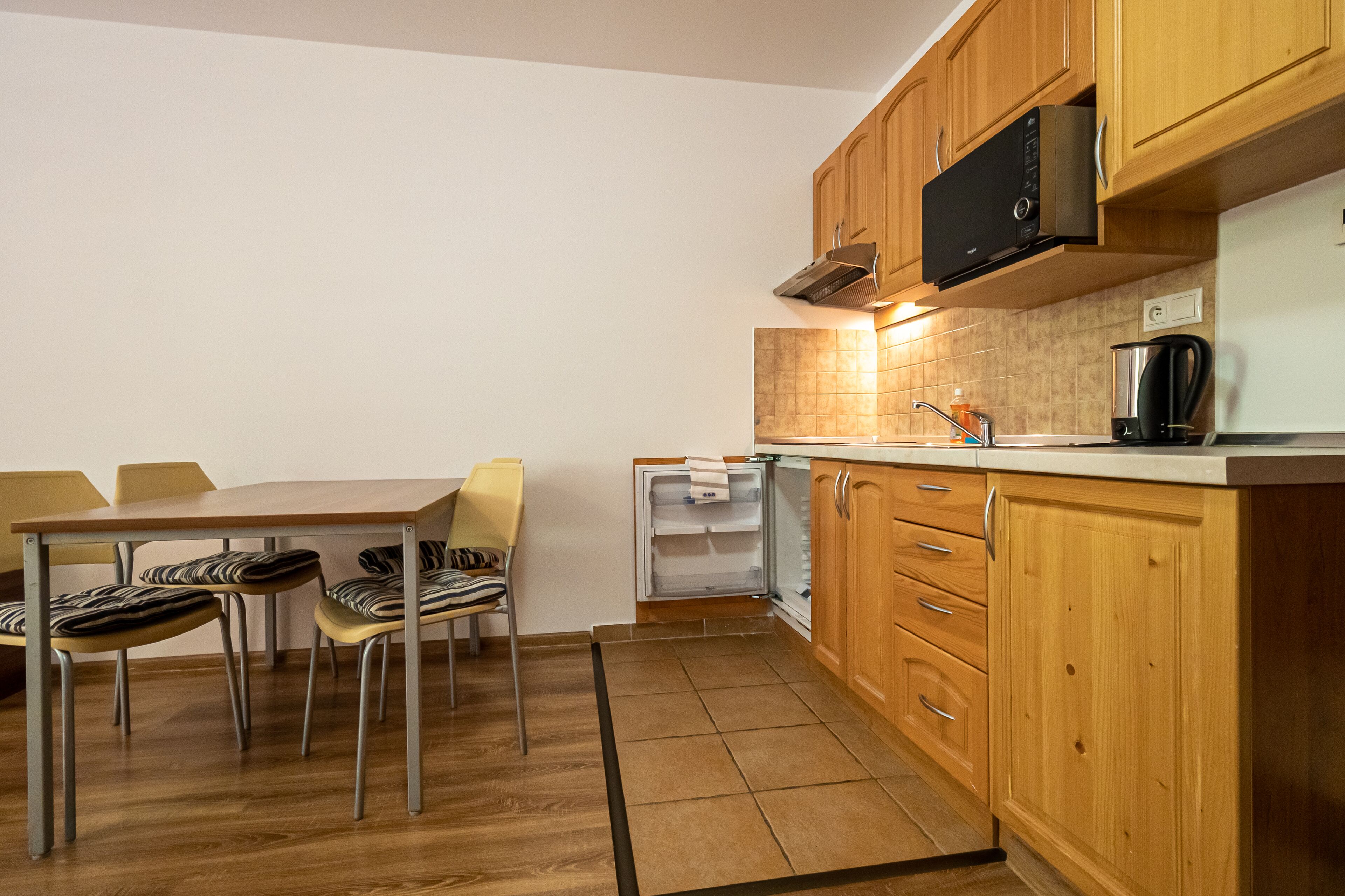 A compact kitchen with wooden cabinets, a built-in microwave, and a small countertop.