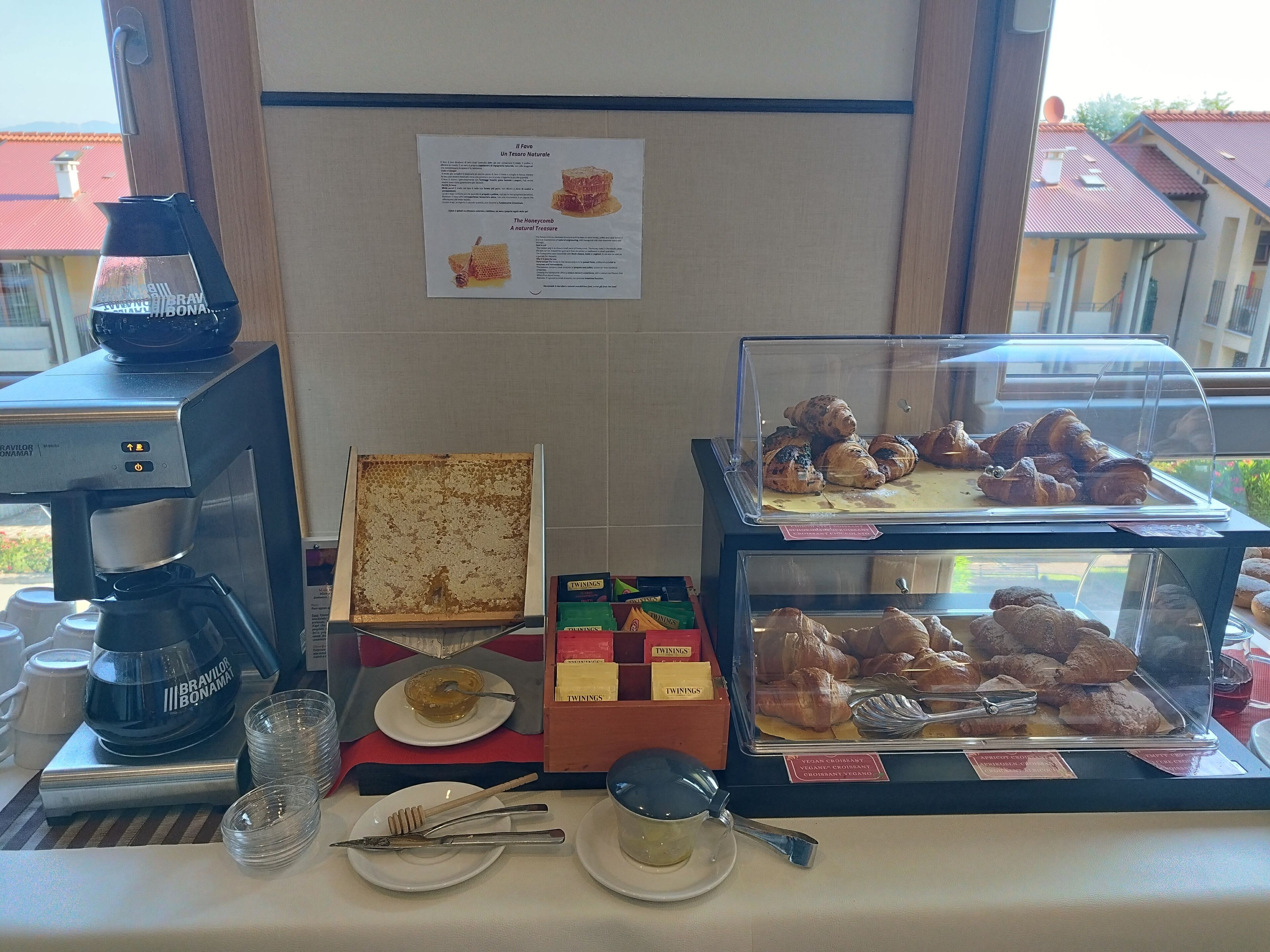 A breakfast buffet with a coffee machine, honeycomb, and various pastries.