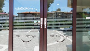 Una puerta de cristal con la frase 'be Happy!' escrita en ella.
