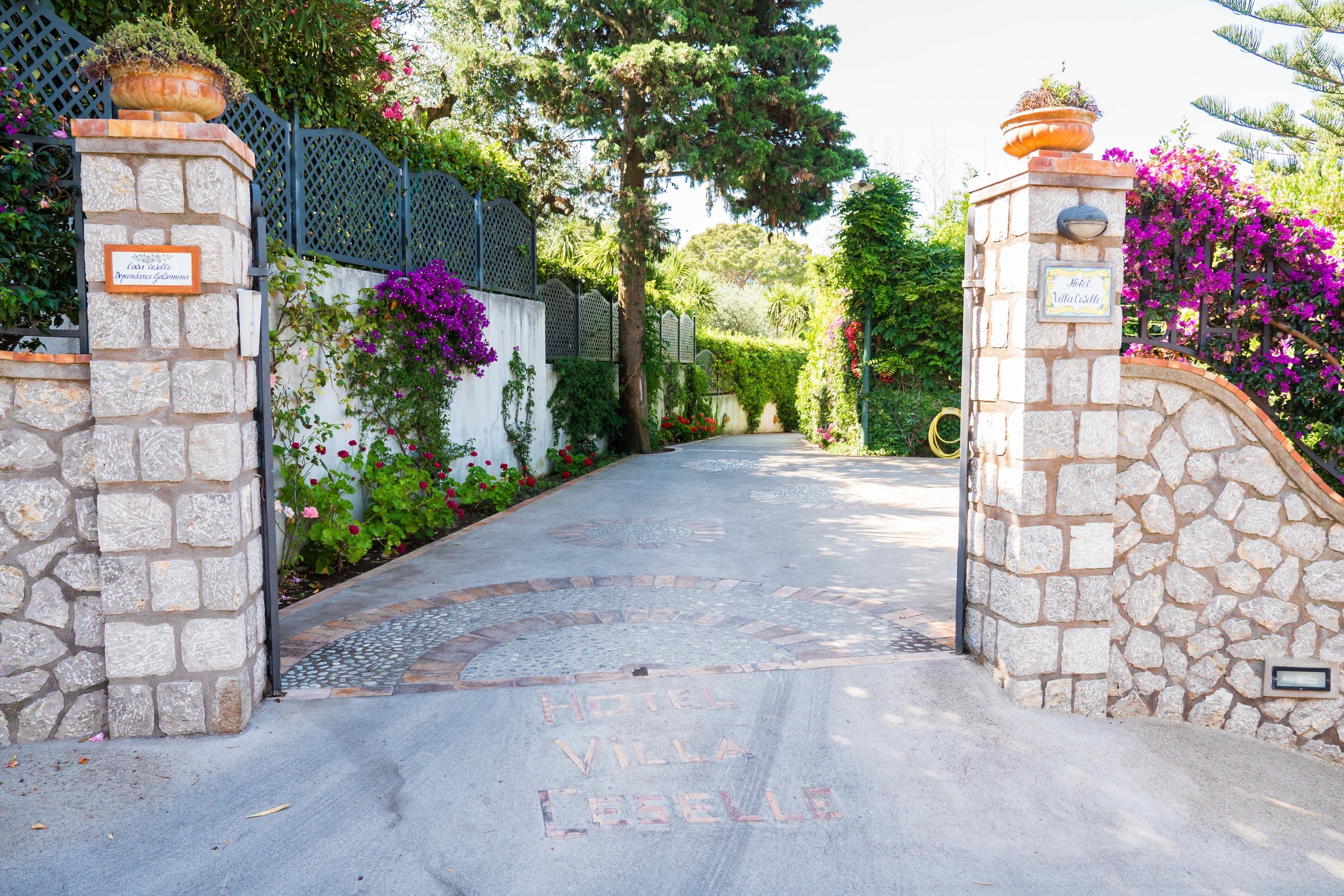 Une porte d’entrée en pierre surmontée d’une enseigne indiquant « Hôtel Villa La Belle ».