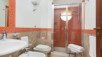 Un bagno con doccia, toilette e due lavandini.