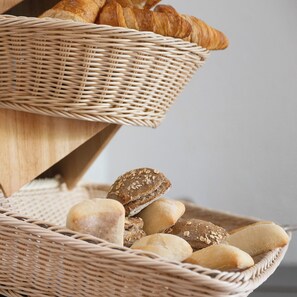 A wicker basket filled with various types of bread and a croissant. - Hôtel Les Afforêts (La Roche-sur-Foron)