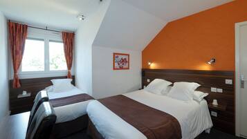 A hotel room with two beds, a window with curtains, a wall-mounted light, and a small painting.
