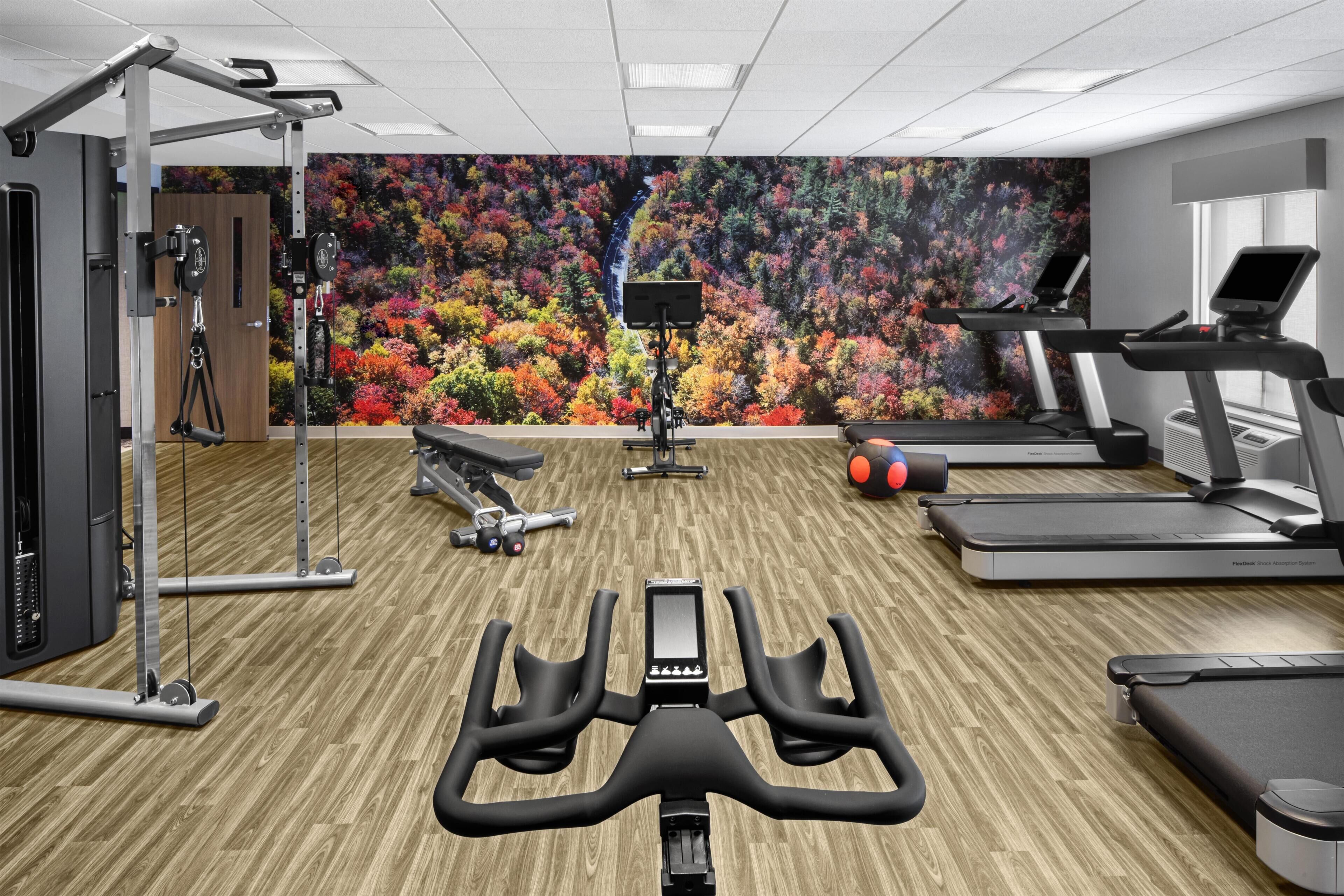 Un gimnasio con equipo de ejercicio, una cinta de correr y una bicicleta estática.