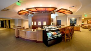 A hotel lobby with a central reception desk, a bar area, and a seating section. - Hyatt Place Boston/Braintree (Braintree)