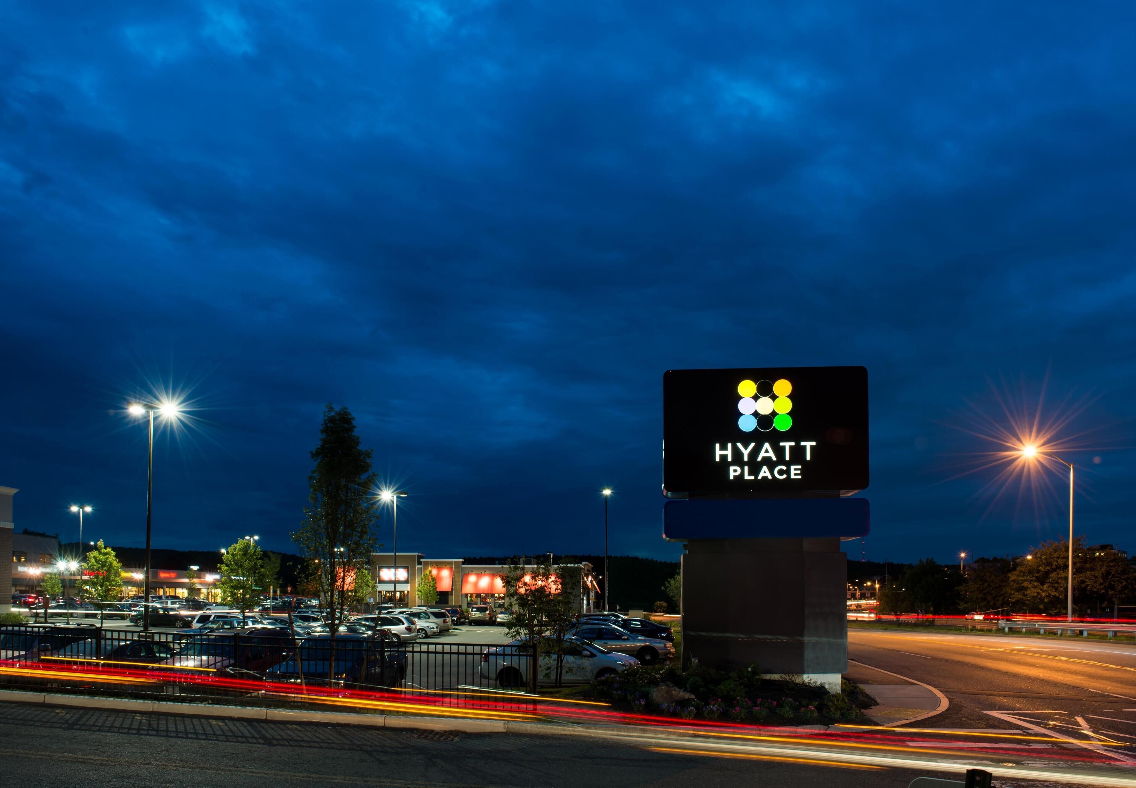 Vista nocturna de un estacionamiento con un cartel de un hotel llamado Hyatt Place.