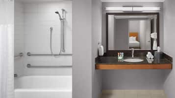 A modern bathroom with a shower, a sink, and a mirror.