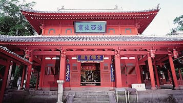 A traditional red building with a tiled roof and a signboard.