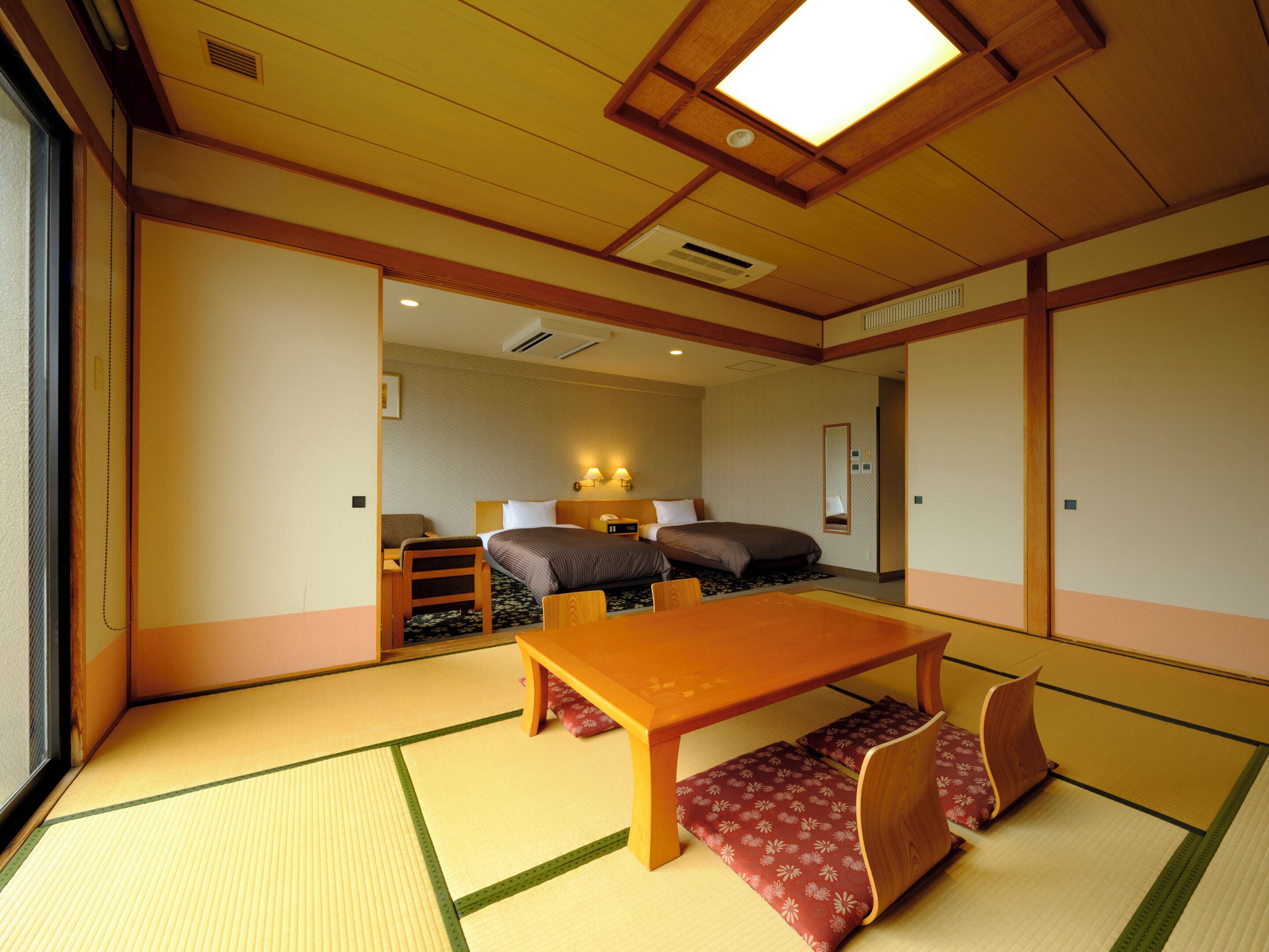 Ein traditioneller japanischer Raum mit Tatami-Bodenbelag, einem niedrigen Holztisch und einem Futon.