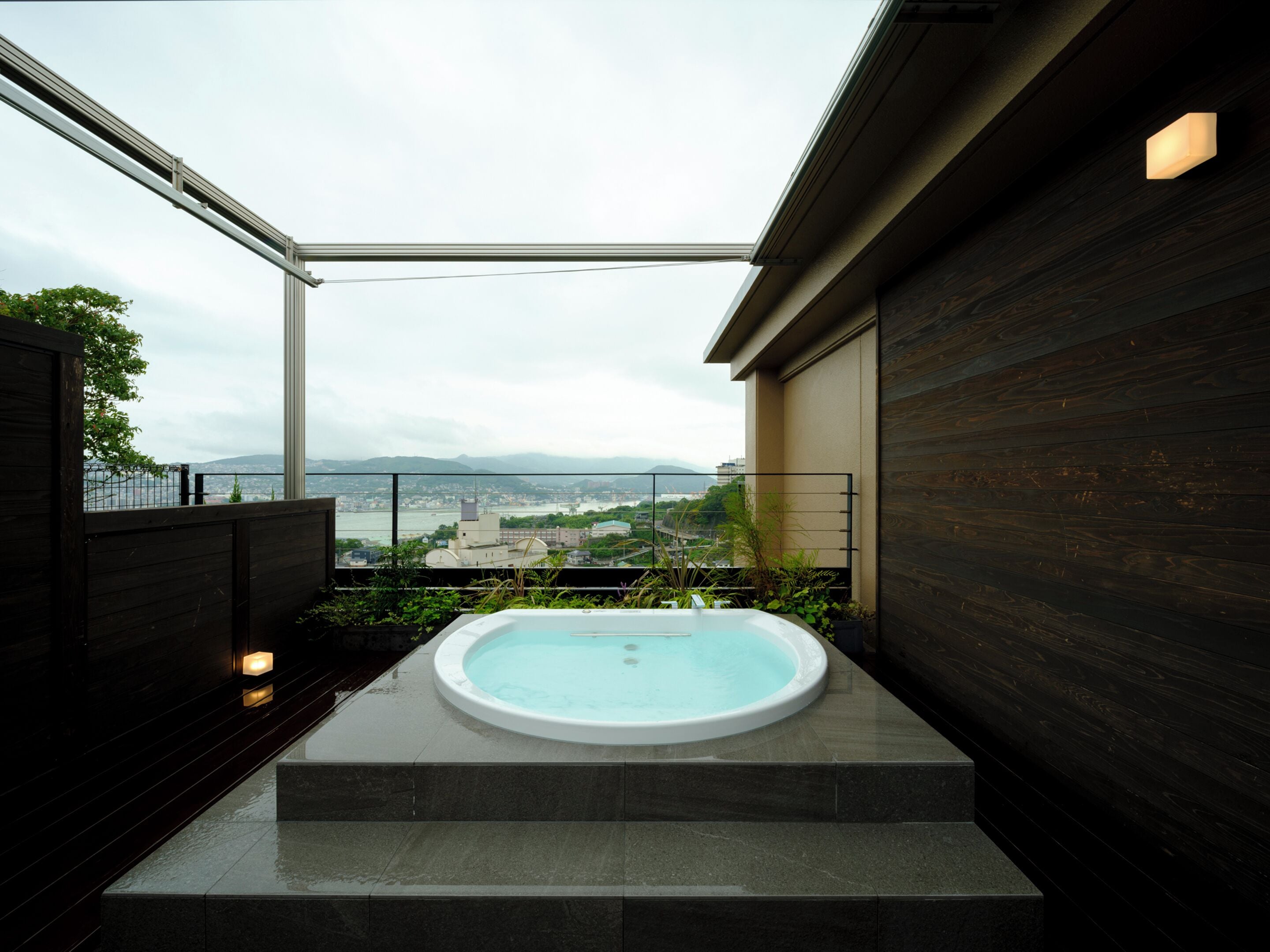 A modern outdoor hot tub with a view of a cityscape.