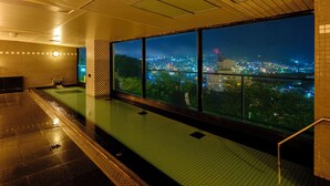 A swimming pool with a city view at night. - Inasayama Kanko Hotel (Nagasaki)
