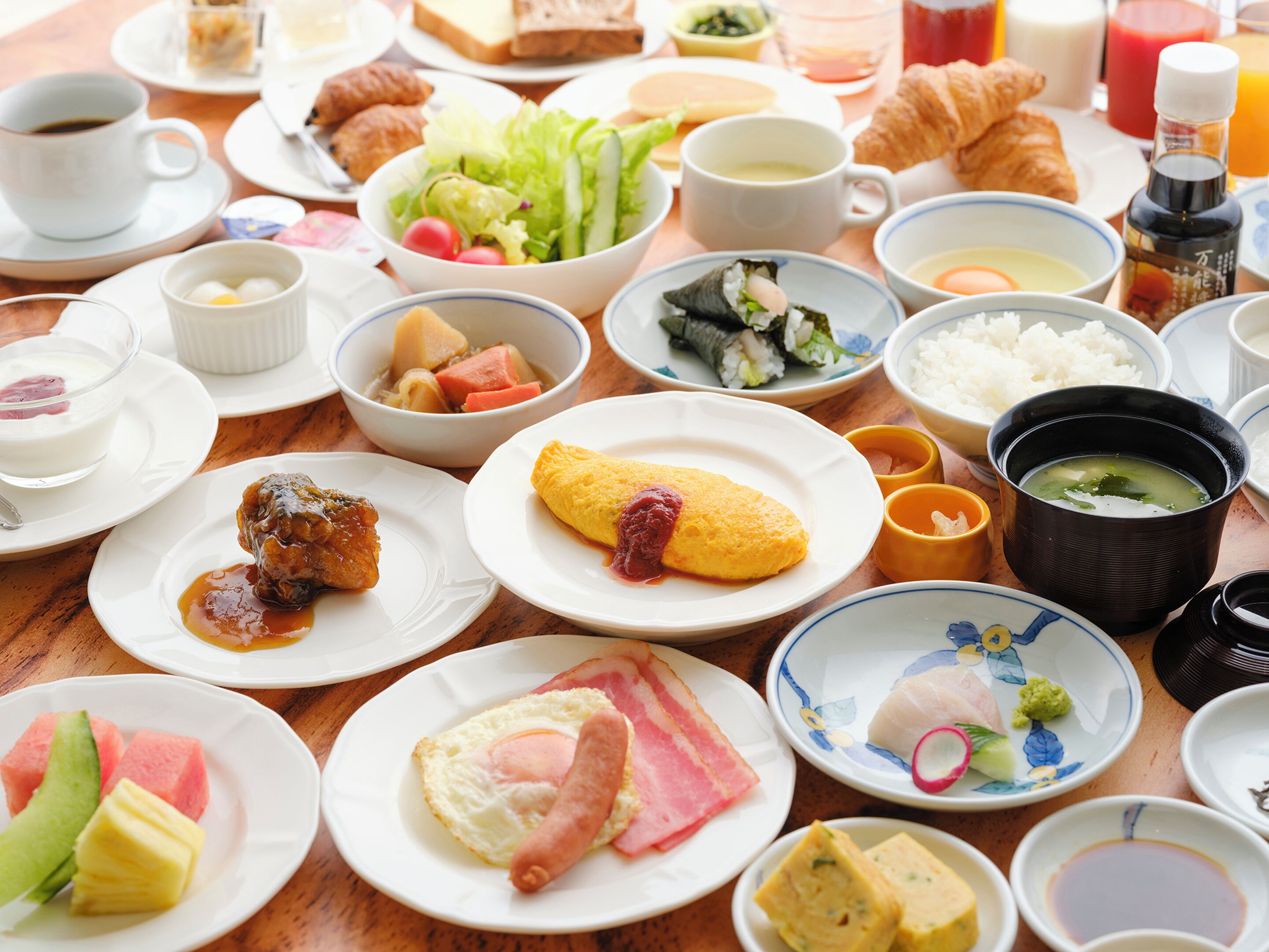 A variety of dishes including sushi, rice, and eggs on a wooden table.
