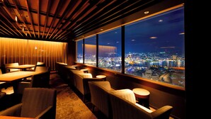 A modern restaurant with a view of a cityscape at night. - Inasayama Kanko Hotel (Nagasaki)