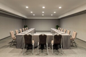 A conference room with a long table, chairs, and ceiling lights.