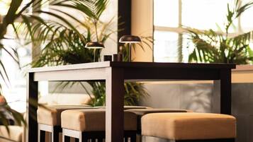 Un área de bar moderna con dos taburetes y una lámpara sobre la barra.