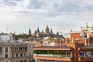 A cityscape with a prominent cathedral in the background, surrounded by residential buildings with balconies and windows.