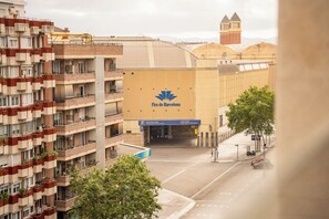 A multi-story building with a parking sign and a tower in the background.