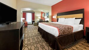 A hotel room with a large bed, a television, and a desk with a chair. - La Quinta Inn & Suites by Wyndham Leesville Ft. Polk (Leesville)