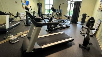 A gym with treadmills, elliptical machines, and weight equipment.