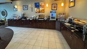 A breakfast bar with various food items and a coffee station.
