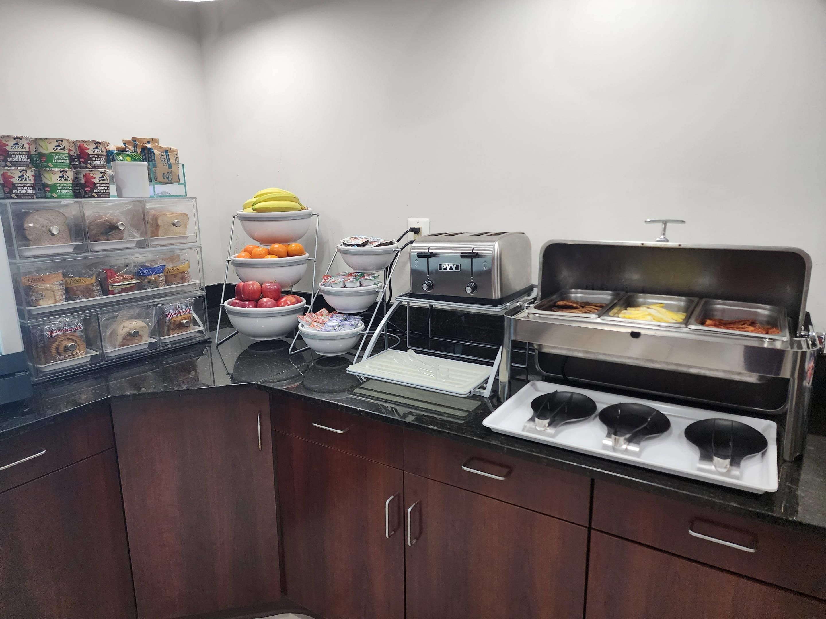 Una mesa de buffet con diversos alimentos y un tostador.