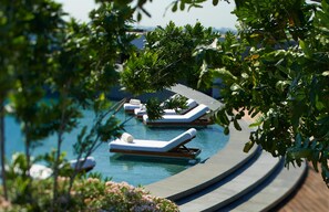A poolside area with lounge chairs and a curved pathway. - Park Hyatt Chennai (Chennai)