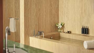 Un bagno moderno con un lavandino capiente, uno specchio e un porta asciugamani.