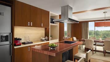 A modern kitchen with wooden cabinets, a central island, and a dining area with chairs and a table.