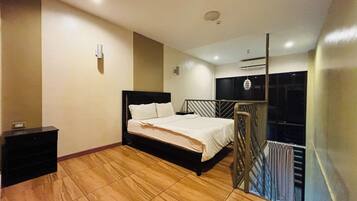 Un dormitorio con cama, mesita de noche, luz empotrada en la pared y unidad de aire acondicionado.